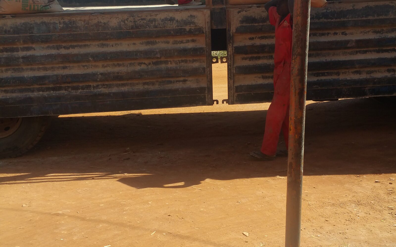 Workers unloading bagged cargo from a distribution truck in Hoima, Uganda